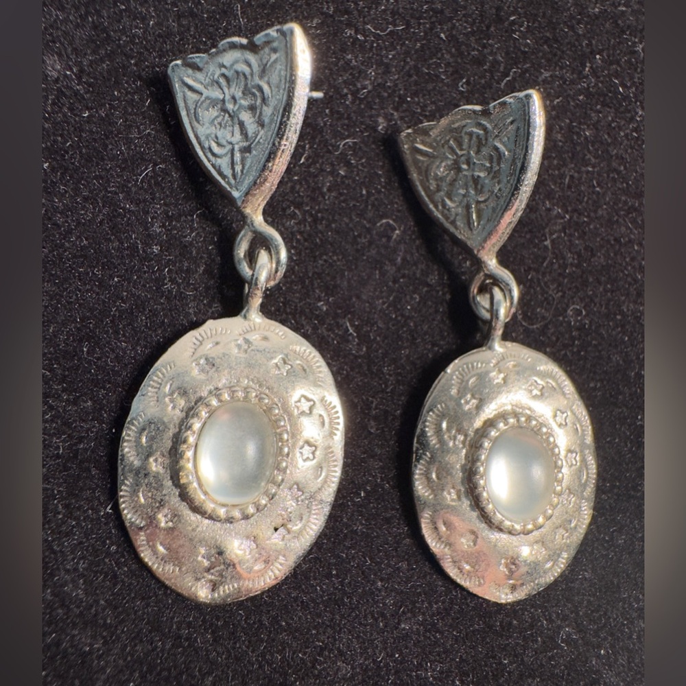 Vintage-style silver tone dangle earrings, oval-shaped, textured medallion drop.